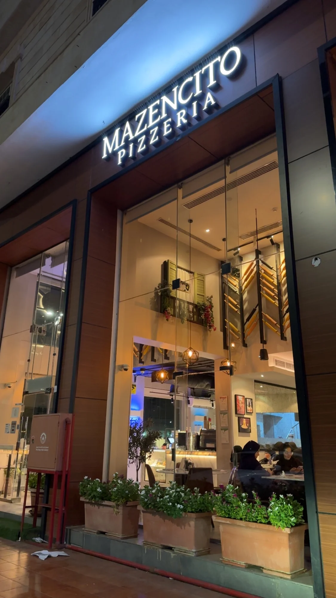 Mazencito Pizzeria entrance glowing at night