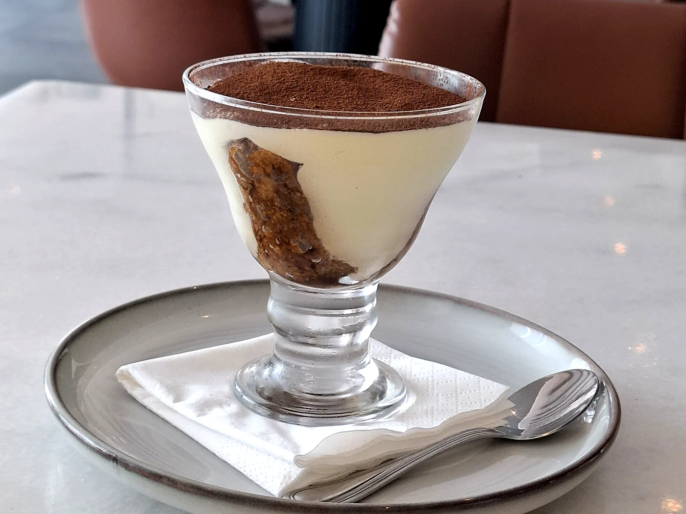 House-made tiramisu in a glass dusted with cocoa