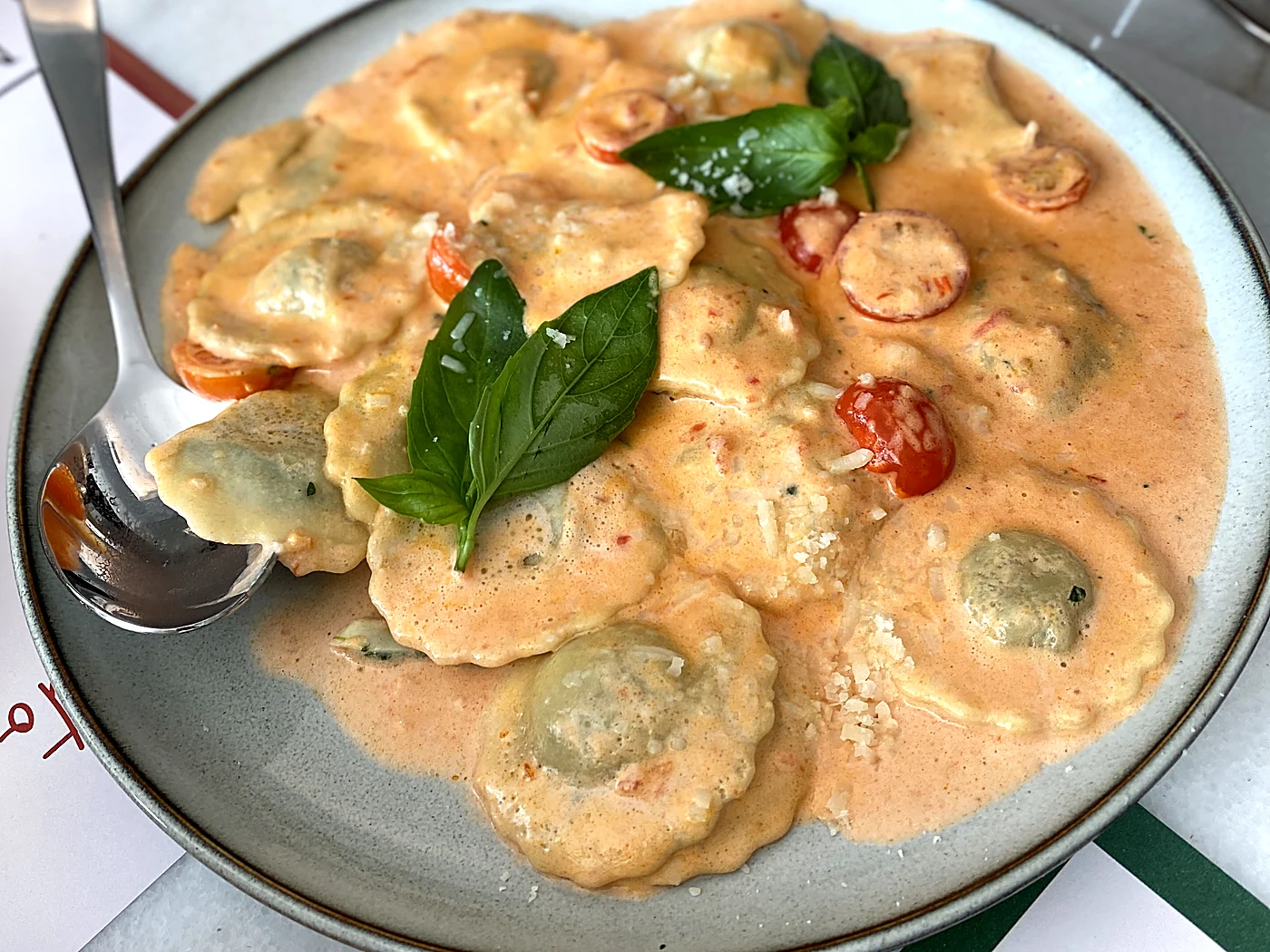 Ricotta and spinach ravioli in a creamy tomato sauce with fresh basil