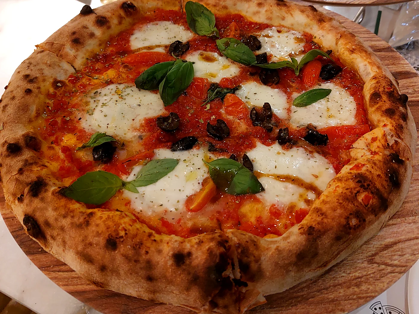 Wood-fired pizza with fresh mozzarella, basil and black olives